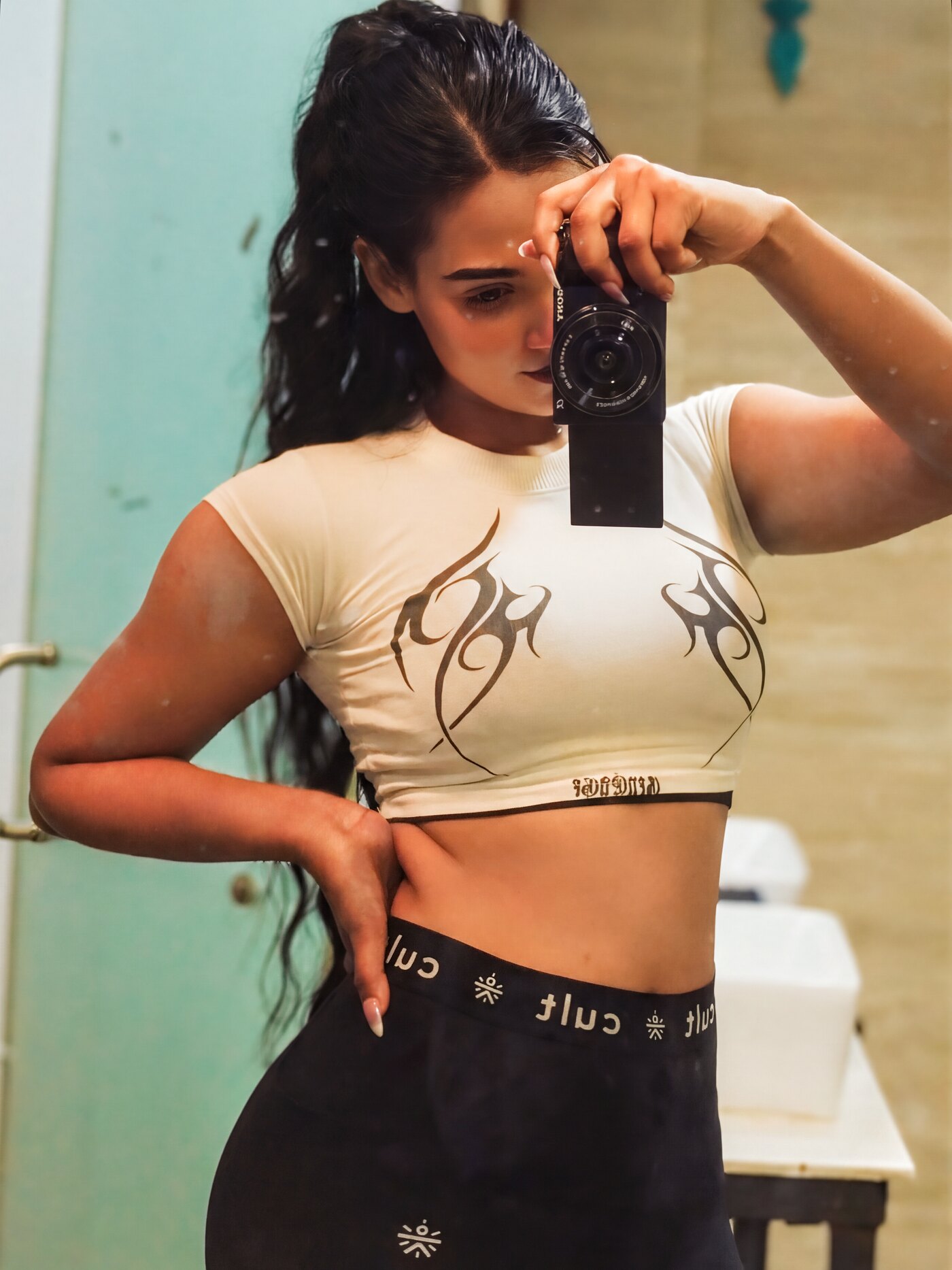 White graphic crop tee, warm street light.